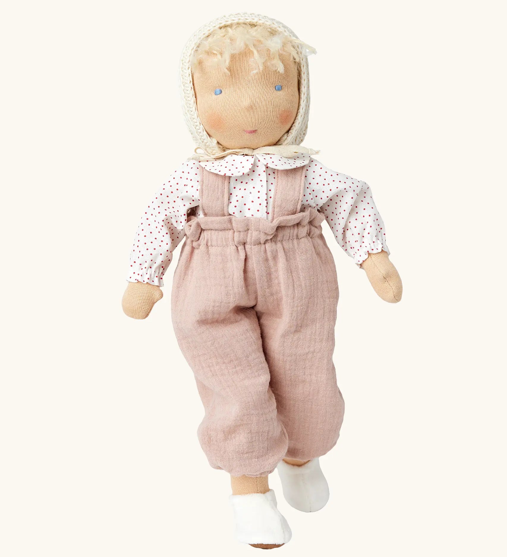 Käthe Kruse Waldorf doll Hannah with blond hair and white skin. Light pink dungarees, white red spotted shirt, cream bonnet and white shoes. 