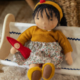 Käthe Kruse Waldorf Doll Kiki in a sitting position with a little red felt gnome.