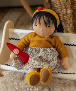 Käthe Kruse Waldorf Doll Kiki in a sitting position with a little red felt gnome.