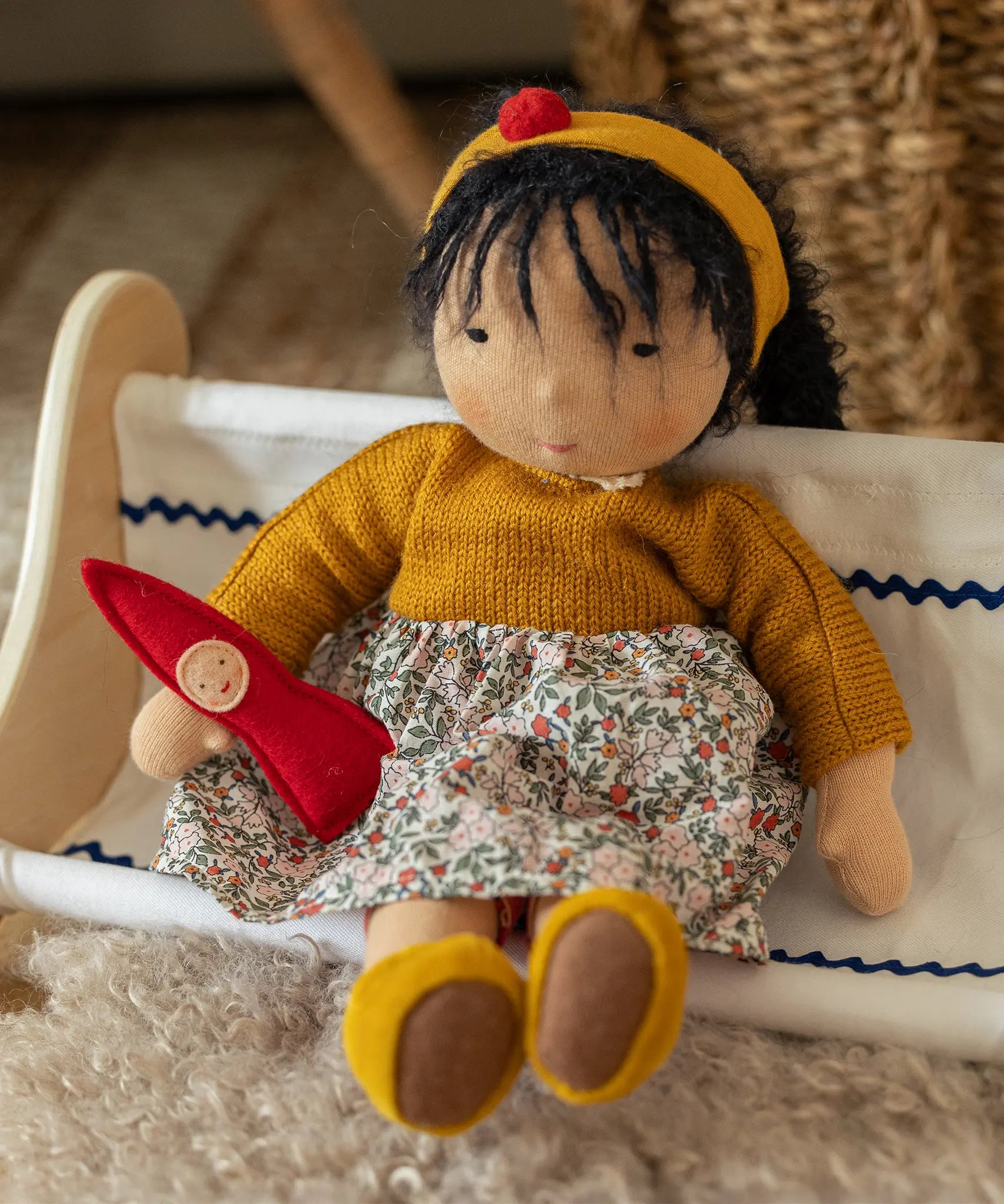 Käthe Kruse Waldorf Doll Kiki in a sitting position with a little red felt gnome.