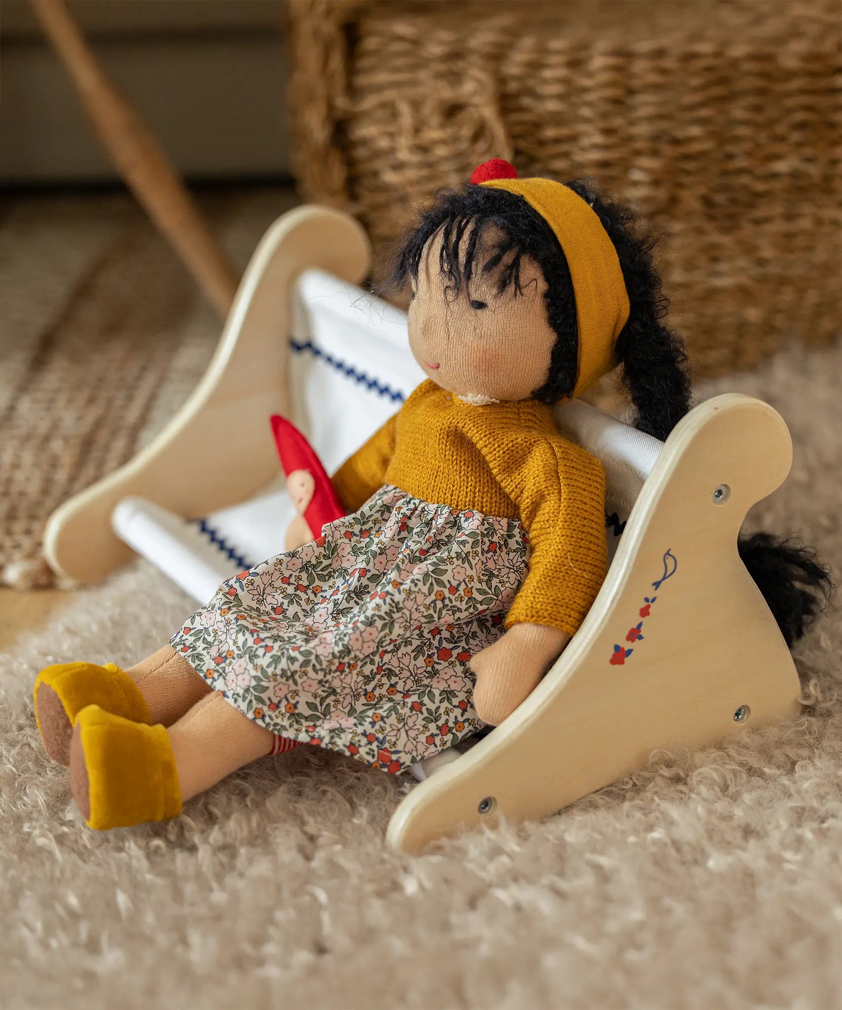 Käthe Kruse Waldorf Doll Kiki in a seated position. Handmade toy made with cotton and filled with natural sheep's wool.