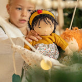 Käthe Kruse Waldorf Doll Kiki being placed in a doll hammock by a child.