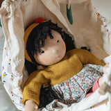 Käthe Kruse Waldorf Doll Kiki laying in a doll hammock.