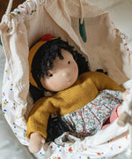 Käthe Kruse Waldorf Doll Kiki laying in a doll hammock.