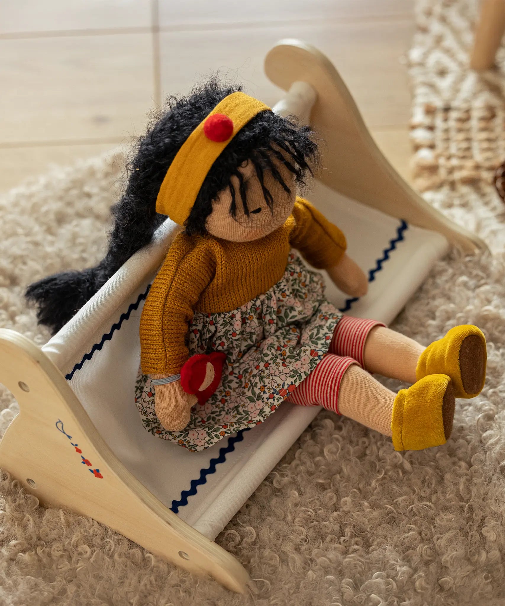 Käthe Kruse Waldorf Doll Kiki in a seated position. handmade doll using cotton and filled with wool. 