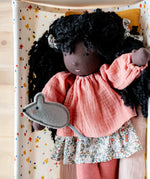 Käthe Kruse Waldorf Doll Nia placed in a doll's crib with small grey felt mouse that comes with it. 