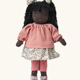  Käthe Kruse Waldorf Doll Nia with long black hair and black skin. Pink knitted jumper, floral print skirt with matching hair bows, red and white stripe leggings and pink booties with white bows.