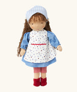 Käthe Kruse Waldorf doll Tilda with long brown hair and fair skin. Blue dotty dress wit red and white striped leggings underneath. White patterned apron and light blue gingham head scarf and red booties.