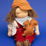 Käthe Kruse Waldorf doll Toni in a sitting position with a small felt squirrel on it's lap. 