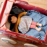 Käthe Kruse Waldorf Doll Kiki laying in a red doll's pram.