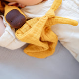 Käthe Kruse ocre yellow small Waldorf Imp doll baby comforter placed next to a baby.