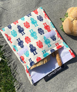 A close up of the organic cotton robot Keep Leaf large baggie outside on a blanket opened with food inside