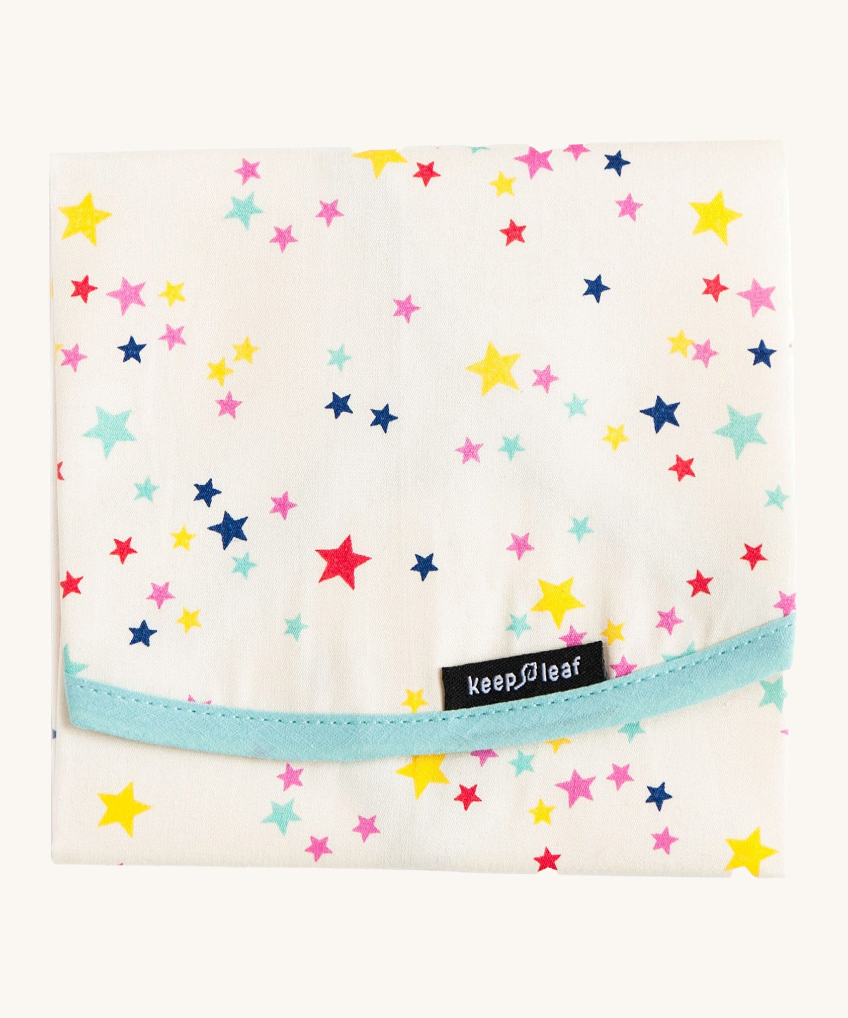 Keep Leaf food wrap in stars design. A cream colour organic cotton wrap for food with multicoloured stars printed all over and light blue trim. Features a velcro lid for easy fastening
