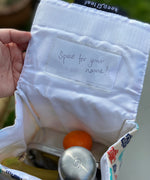 A close up of the pouch on the inside of the lid showing a name tag. 