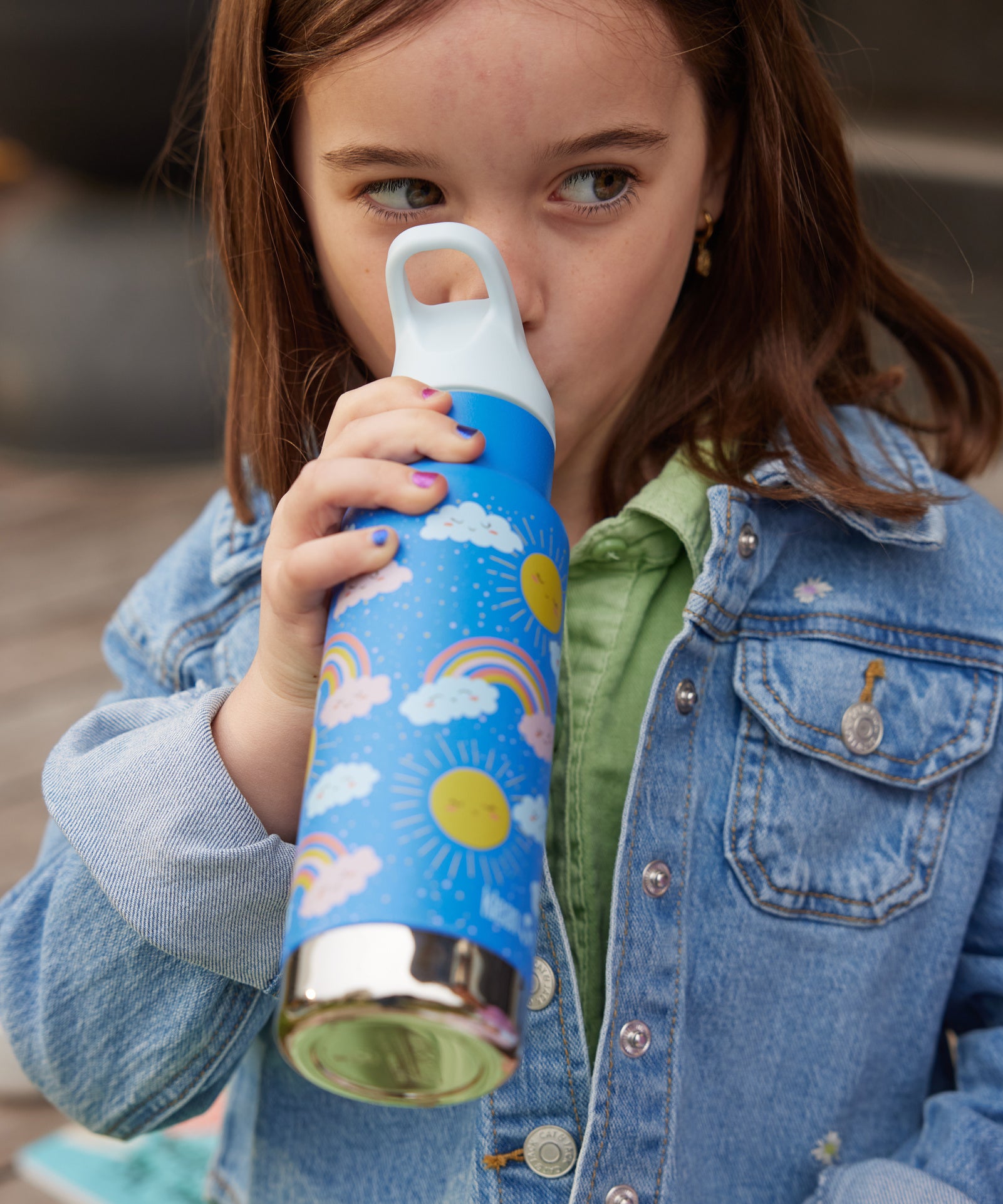 A child drinking from a Rainbow print Kid Kanteen 12oz Insulated Flip Seal Sport Cap Bottle. 