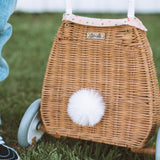 The back view of the Olli Ella Rattan Bunny Luggy with Lining – Gumdrop. A beautifully woven Luggy roll along basket with a light peach lining and gum drop detail