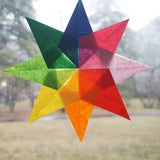 8 point star in rainbow colours made from kite wax paper stuck on a window