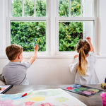 Two children drawing with the Kitpas eco-friendly coloured crayons on a window