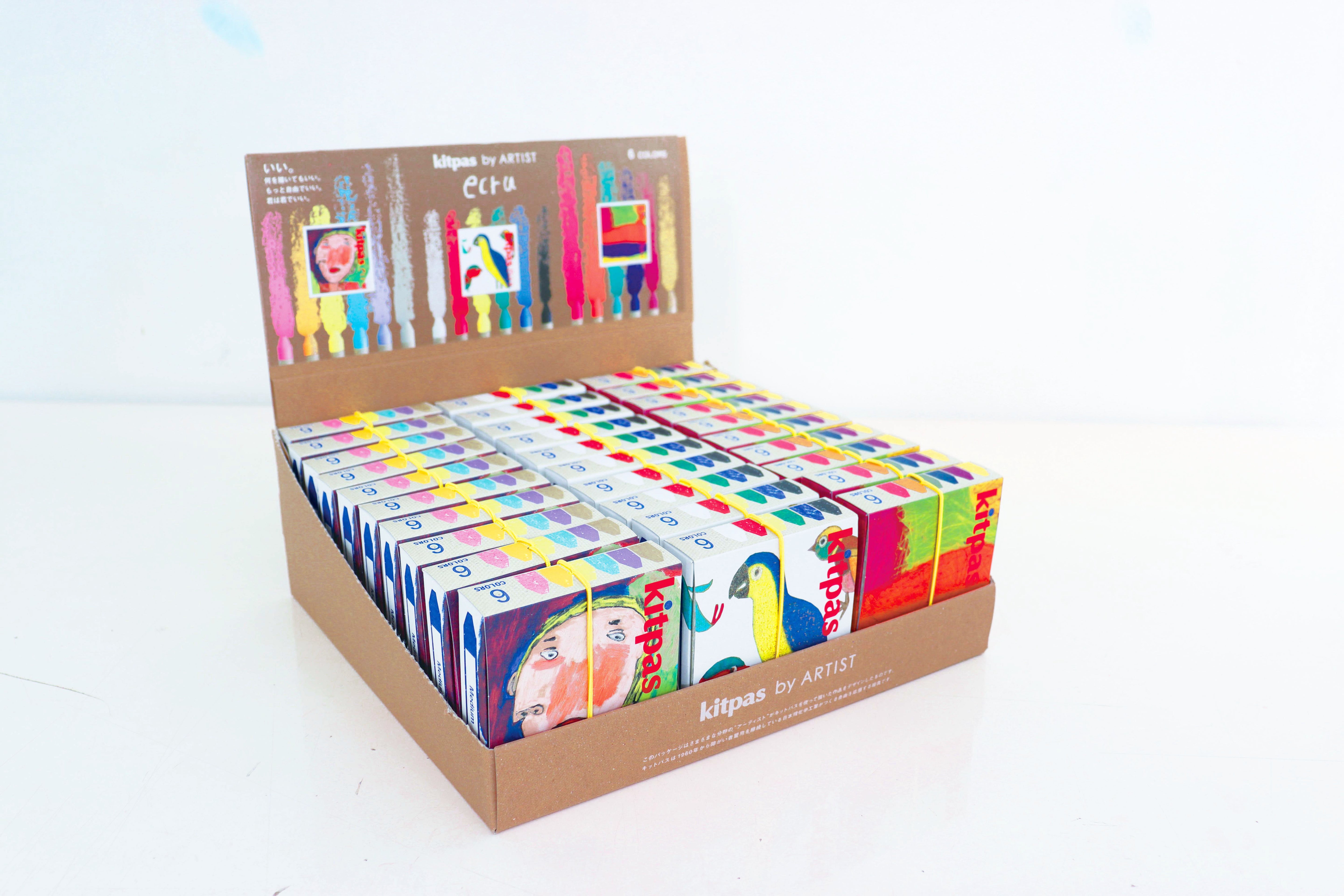 A display box containing all three Kitpas artist collection 6 packs of crayons. The box shows the colours of the crayons inside each pack. 