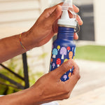 A close up of a mushroom print Kid Kanteen 12oz Narrow Sippy Bottle in an adult's hand. 
