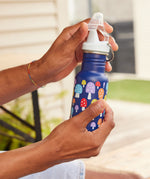 A close up of a mushroom print Kid Kanteen 12oz Narrow Sippy Bottle in an adult's hand. 
