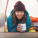 An adult enjoying a drink from their Klean Kanteen 12oz Insulated Camping Mug in White