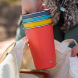 Klean Kanteen stainless steel 16oz pint cups in a 4 Pack in evening sky colours stacked together in a person's hands.