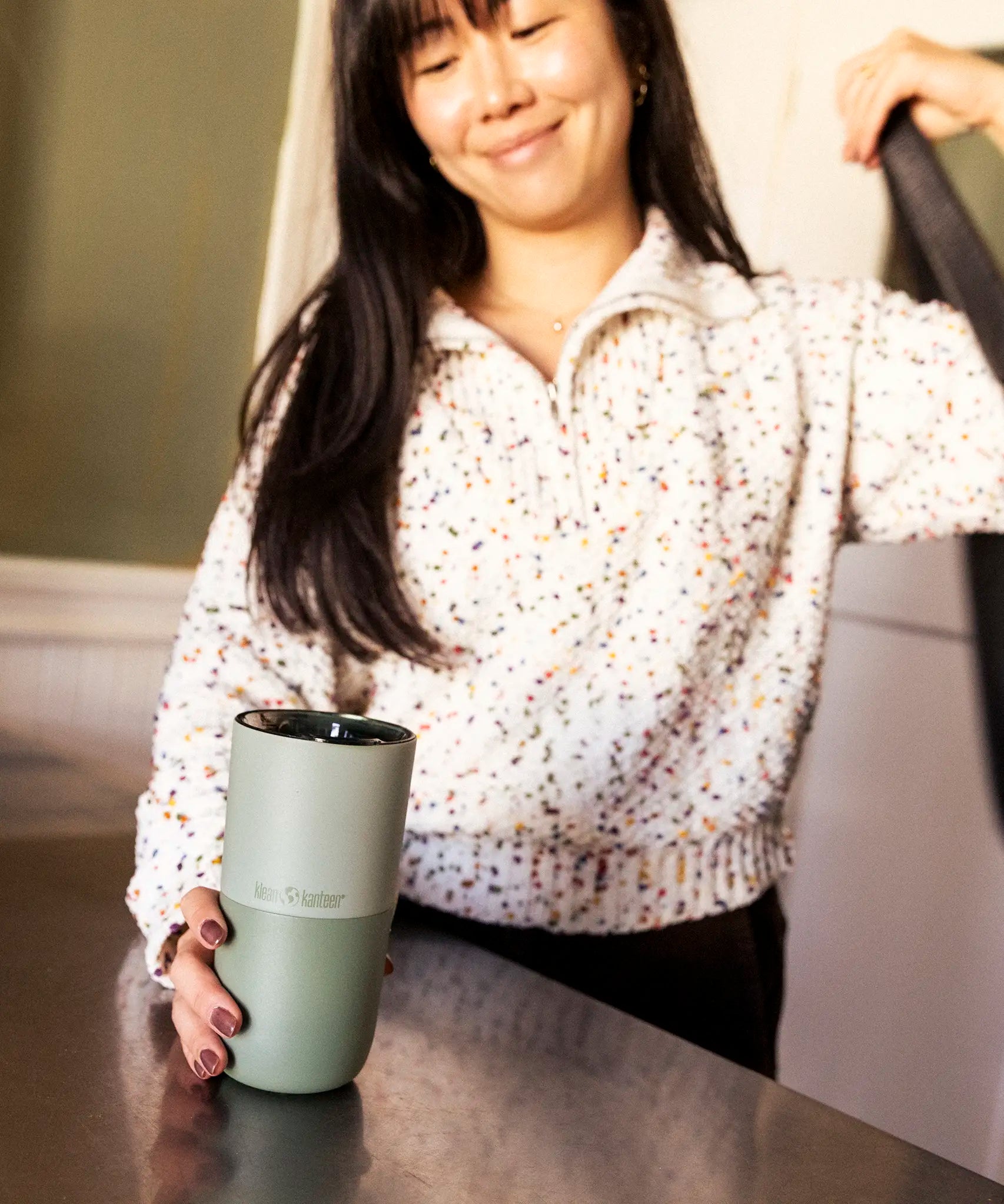 Adult grabbing a 16oz Klean Kanteen in iceberg green