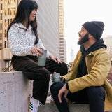 Adult holding a 16oz iceberg Klean Kanteen tumbler and another adult holding a 8oz lowball tumbler in the city
