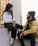 Adult holding a 16oz iceberg Klean Kanteen tumbler and another adult holding a 8oz lowball tumbler in the city