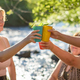 People cheering with drinks served in the Klean Kanteen stainless steel 16oz pint cups in evening sky colours.