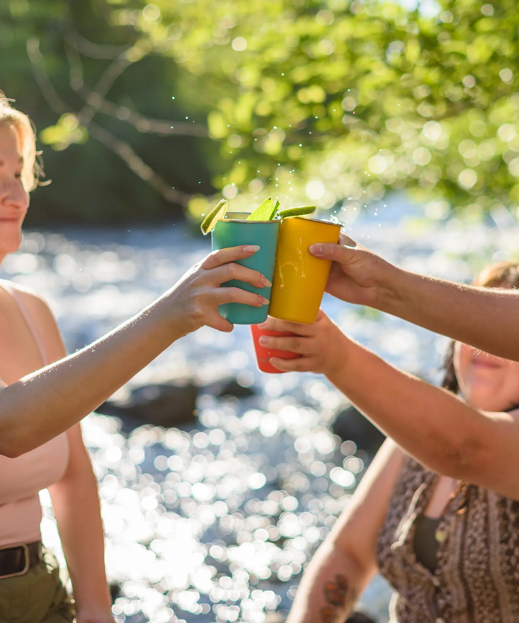 People cheering with drinks served in the Klean Kanteen stainless steel 16oz pint cups in evening sky colours.