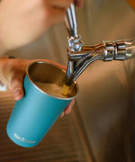 Pint being poured into a blue Klean Kanteen stainless steel 16oz pint cup.