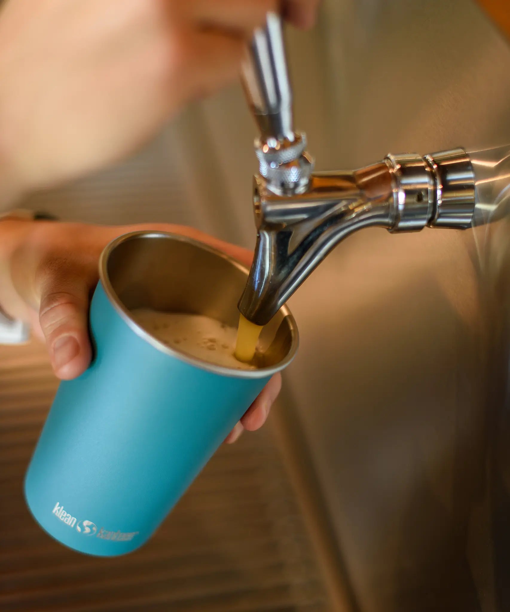 Pint being poured into a blue Klean Kanteen stainless steel 16oz pint cup.