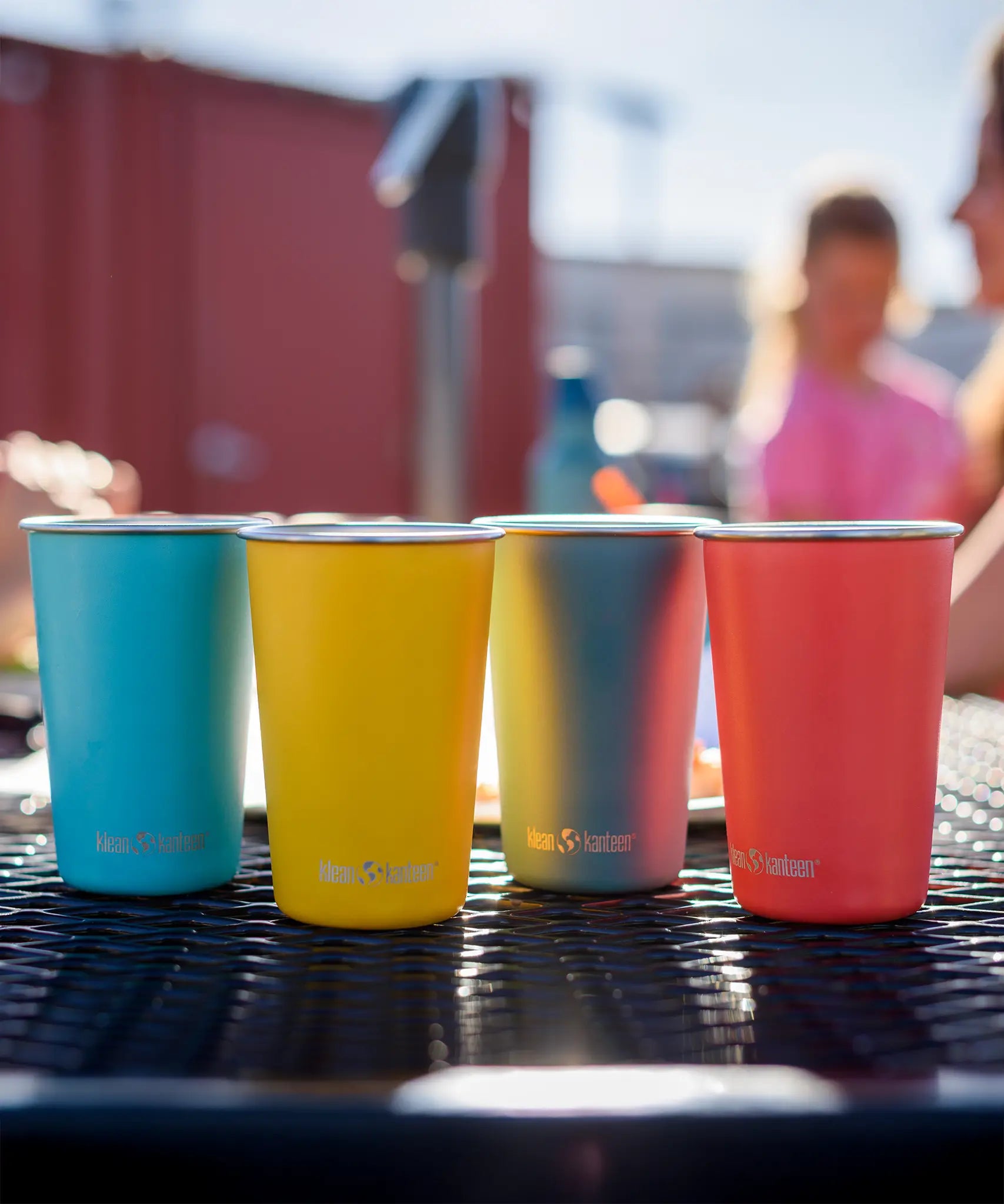 Klean Kanteen stainless steel 16oz pint cups in a 4 Pack in evening sky colours placed on a garden table.