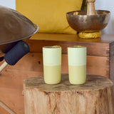 Pair of Klean Kanteen wax yellow 16oz stainless steel rise tumblers standing on a wooden table