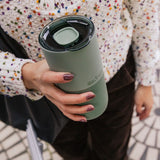 Woman holding a Klean Kanteen 26oz tumbler  in sea spray green with a large 90mm rise slide lid on top