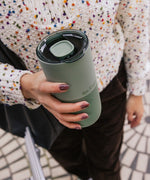 Woman holding a Klean Kanteen 26oz tumbler  in sea spray green with a large 90mm rise slide lid on top