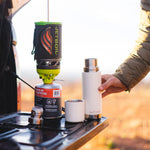 Close up of a Klean kanteen reusable tkpro flask on a car tailgate next to some camping equipment