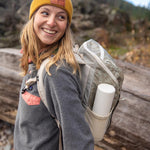 Woman smiling and wearing a rucksack with a Klean kanteen 500ml steel tkpro flask in the side pocket