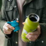 Close up of hands holding a Klean Kanteen insulated bottle and a replacement sports lid