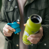 Close up of hands holding a Klean Kanteen insulated bottle and a replacement sports lid