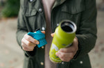 Close up of hands holding a Klean Kanteen insulated bottle and a replacement sports lid