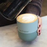 Adult hand holding a Klean Kanteen 8oz iceberg green lowball tumbler filled with coffee