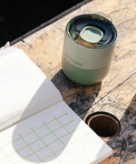 A iceberg green Klean Kanteen 8oz lowball tumbler with the slide lid on top standing on a wooden table