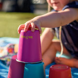 Child stacking the Klean Kanteen stainless steel kid cups in the gum drops colour way on top of each other. 