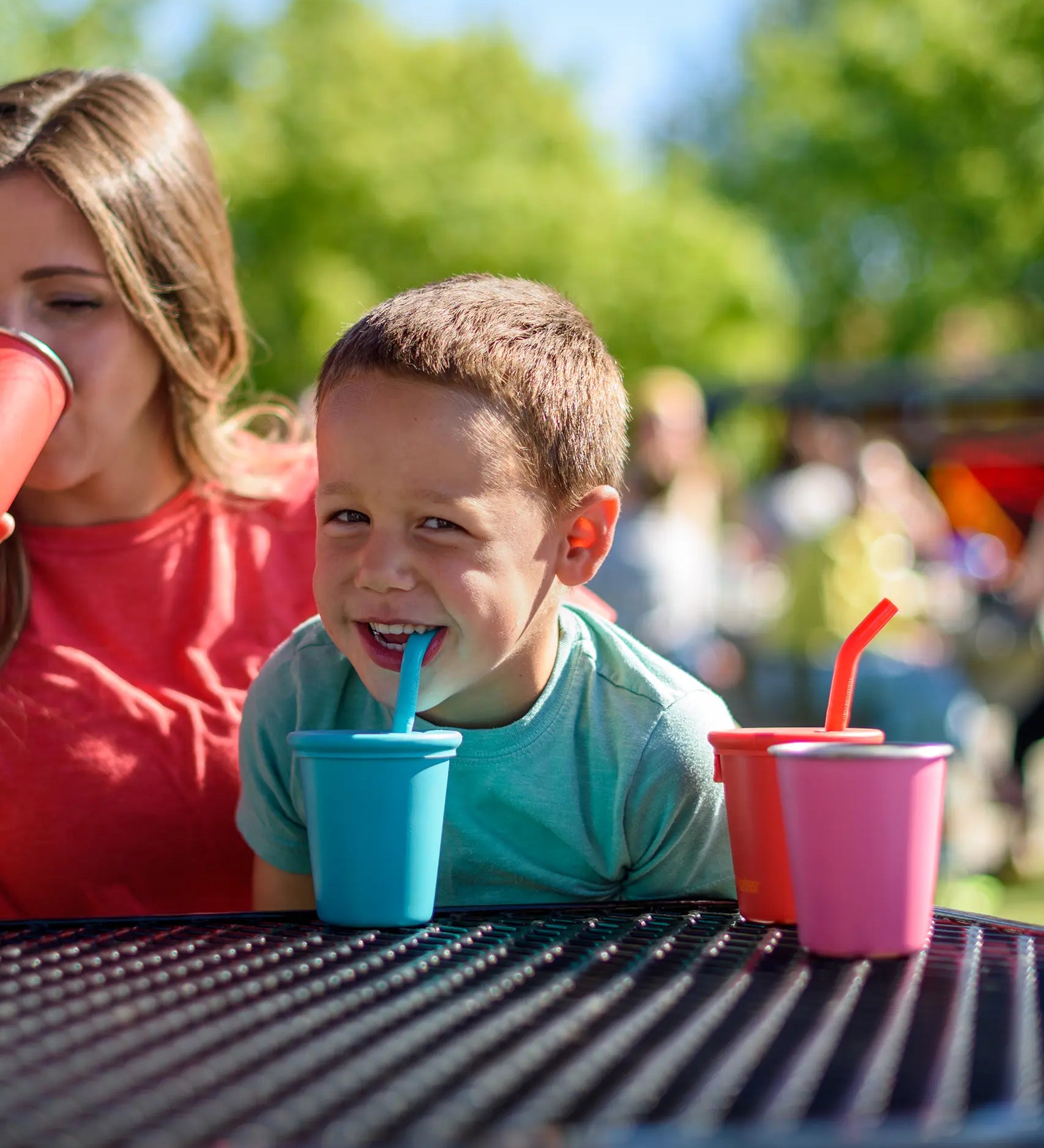 Child drinking from a blue Klean Kanteen 10oz/296ml Steel Kid Cups with Straw Lid.