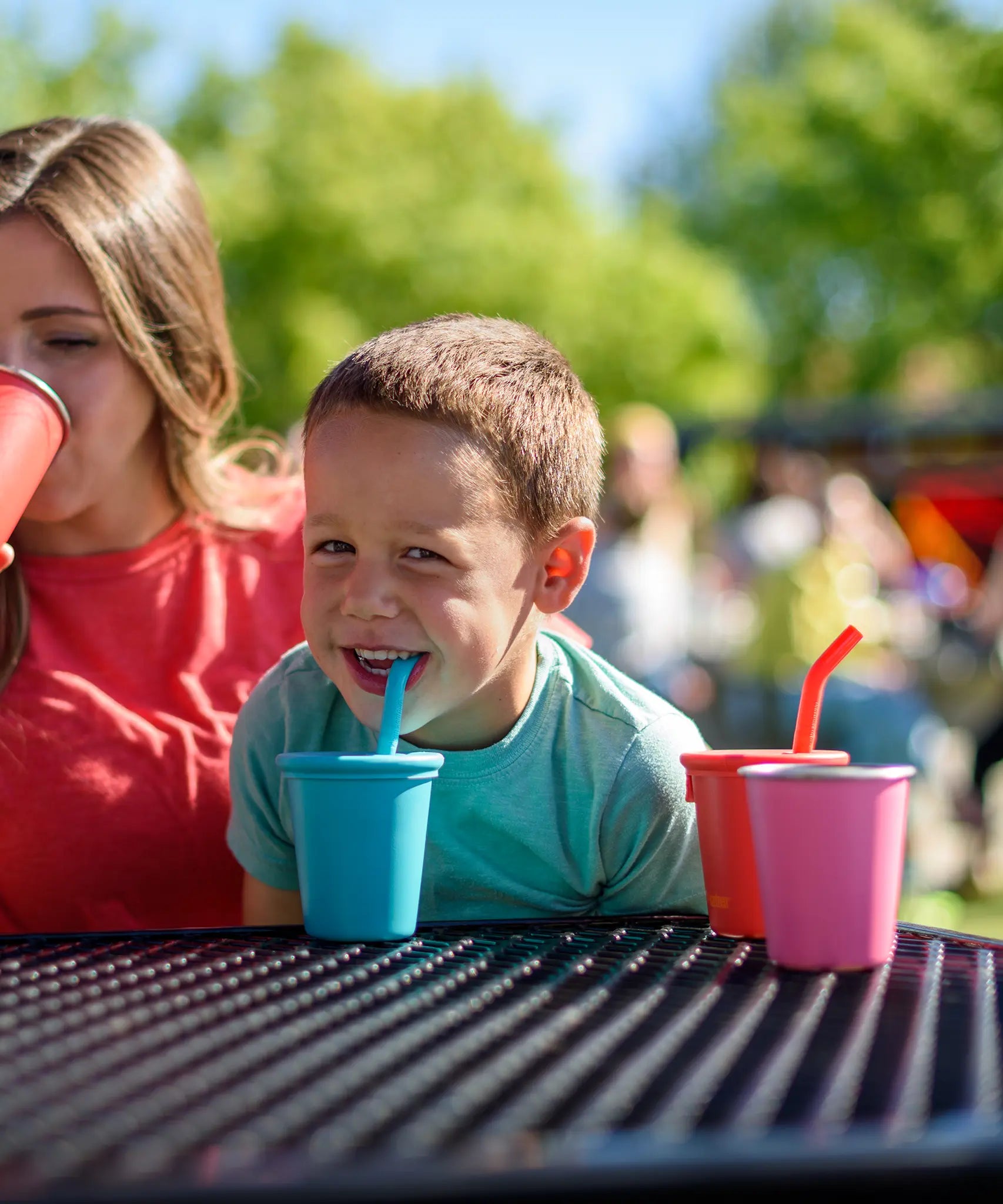 Child drinking from a blue Klean Kanteen 10oz/296ml Steel Kid Cups with Straw Lid.