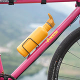 Golden yellow Klean Kanteen bottle with Flip Seal Sports Cap mounted on a bicycle during a ride