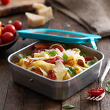 Klean Kanteen 20oz food box filled with tomato and cheese pasta on a wooden worktop next to a bowl of tomatoes and a fork